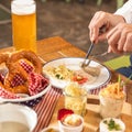 Man cutting tasty German sausage with beer