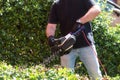 Man cutting and trimming bushes and hedges with Hedge Trimmer