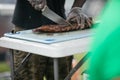 A man cutting up barbeque ribs from the smoker grill on cutting board with gloves on and a large knife. Royalty Free Stock Photo