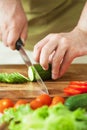 Man cutting vegetables for salad