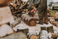 Woodcutter working with chainsaw at sawmill