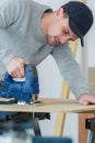 Man cutting woodplank using bandsaw