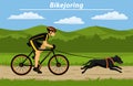 Man cycling bikejoring with his dog outside