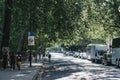 Man cycling past cars in traffic in London, UK, in summer, motion blur