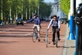 Man cycling and pushing another bicycle