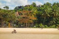 man cycling on tropical sunny beach, sideview Royalty Free Stock Photo