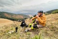 Man cyclist resting after riding electric bike, drinking a cup of tea in the mountains. Royalty Free Stock Photo