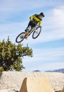 Man, cyclist and mountain biking in free style, tricks or extreme hill jumping in the nature outdoors. Professional male