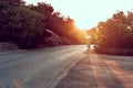 Man cyclist pedaling on a road bike outdoors in sun set