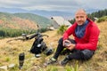 Man cyclist resting after riding electric bike, drinking a cup of tea in the mountains. Royalty Free Stock Photo