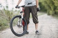 Man cyclist standing with his bike at country road Royalty Free Stock Photo