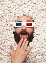 Man in 3-D glasses lying in popcorn