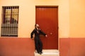 Man dancing flamenco with black shirt and red roses, on the background of a red wooden door, he is waiting leaning on the door. Royalty Free Stock Photo