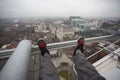 Man dangling feet over city view