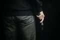 Man in dark clothing is holding gun. Royalty Free Stock Photo