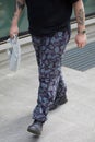 Man with dark purple and blue floral pattern trousers before Emporio Armani fashion show, Milan