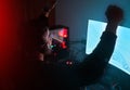 Man in dark room, video game win with fist pump and online streaming, gaming competition and esports on computer
