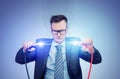 A man in a dark suit and glasses holds two thick wires with clips between which a powerful electrical discharge occurs Royalty Free Stock Photo