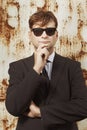 Man in dark suit  and tie posing for portrait by rusty white wall Royalty Free Stock Photo