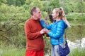 Man on a date gives woman a bell flower in the summer in a park on the lake shore