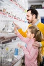 Man and daughter deciding on best bird to keep