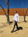 Man in Deadvlei valley, dried lake in desert of Namibia. Sossusvlei dead vlei. Royalty Free Stock Photo