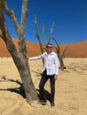 Man in Deadvlei valley, dried lake in desert of Namibia. Sossusvlei dead vlei. Royalty Free Stock Photo