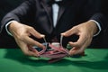 Man dealer or croupier shuffles poker cards in a casino on the background of a table, poker game concept Royalty Free Stock Photo