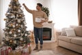 Man decorating Christmas tree in beautiful room interior Royalty Free Stock Photo