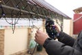 Man decorating house with Christmas lights outdoors, closeup Royalty Free Stock Photo