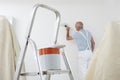 Man Decorating Room With Can Of Paint And Brush In Foreground Royalty Free Stock Photo