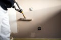 Man decorating walls with paint. Construction plaster worker painting and renovating with professional tools