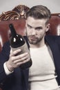 Man degustator with beard, stylish hair hold wine bottle Royalty Free Stock Photo