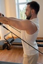 Kneeling pulley exercise, practicing on reformer pulley row focusing on shoulder control Royalty Free Stock Photo