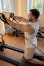 Kneeling pulley exercise, practicing on reformer pulley row focusing on shoulder control Royalty Free Stock Photo