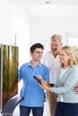 Man Demonstrating New Television To Mature Couple At Home Royalty Free Stock Photo