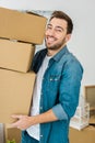 Man in denim jacket holding cardboard boxes and looking at camera Royalty Free Stock Photo