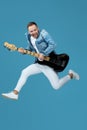 Man in denim t-shirt jeans with guitar jumping