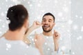 Man with dental floss cleaning teeth at bathroom Royalty Free Stock Photo