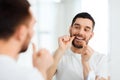 Man with dental floss cleaning teeth at bathroom Royalty Free Stock Photo