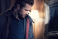 Man detail wearing anorak jacket portrait indoor at home looking down. Europe Alps. Winter evening