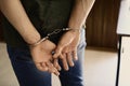 Man detained in handcuffs indoors. Criminal law Royalty Free Stock Photo
