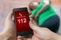 Man dialing emergency (112 number) on smartphone. Woman had hear