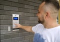 The man dials the code for the video intercom outside the building to go home. Royalty Free Stock Photo