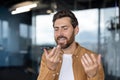 Man dictating voice message on smartphone in office Royalty Free Stock Photo