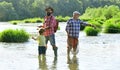 Man in different ages. Fishing. Grandpa and grandson are fly fishing on river. Man teaching kids how to fish in river.