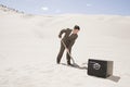 Man digging by safe in desert Royalty Free Stock Photo