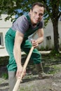 Man digs hole in ground for planting trees Royalty Free Stock Photo