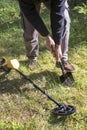 Man digs a hole in the ground using a shovel. Searching for militaries. The metal detector lies on the grass next to it. Royalty Free Stock Photo