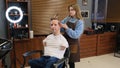 a man with disabilities gets his hair cut and styled in a barber shop.